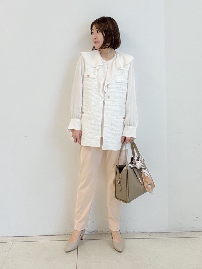 ベージュ系のパンプス、オレンジ系のその他パンツ、ベージュ系のハンドバッグを着用したレディースの春コーディネートの2枚目の写真