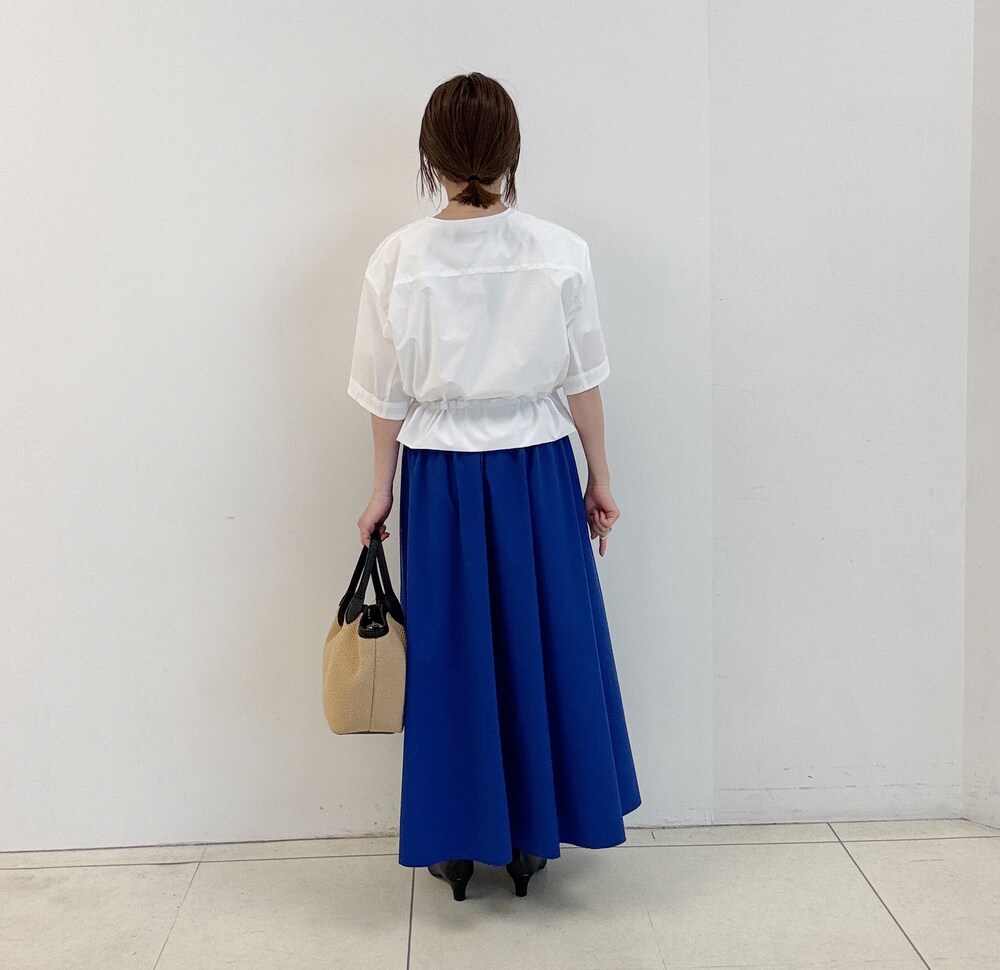ホワイト系のTシャツ/カットソー、ブラック系のパンプス、ブルー系のスカートを着用したレディースの春コーディネートの4枚目の写真