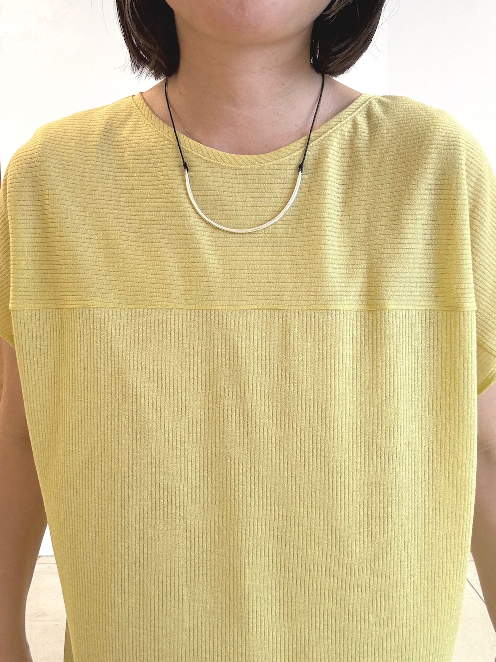 ブラック系のパンプス、イエロー系のTシャツ/カットソー、ホワイト系のハンドバッグを着用したレディースの春コーディネートの4枚目の写真