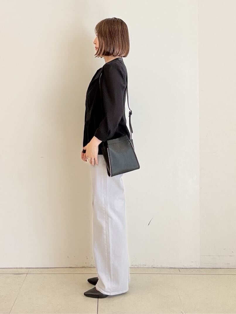 グレー系のデニムパンツ、ブラック系のシャツ/ブラウス、ブラック系のショルダーバッグを着用したレディースの春コーディネートの3枚目の写真