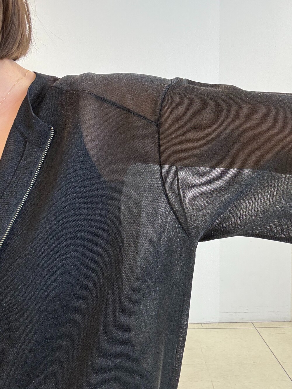 ブラック系のカーディガン/ボレロ、グレー系のスカート、ブラック系のタンクトップを着用したレディースの春コーディネートの5枚目の写真