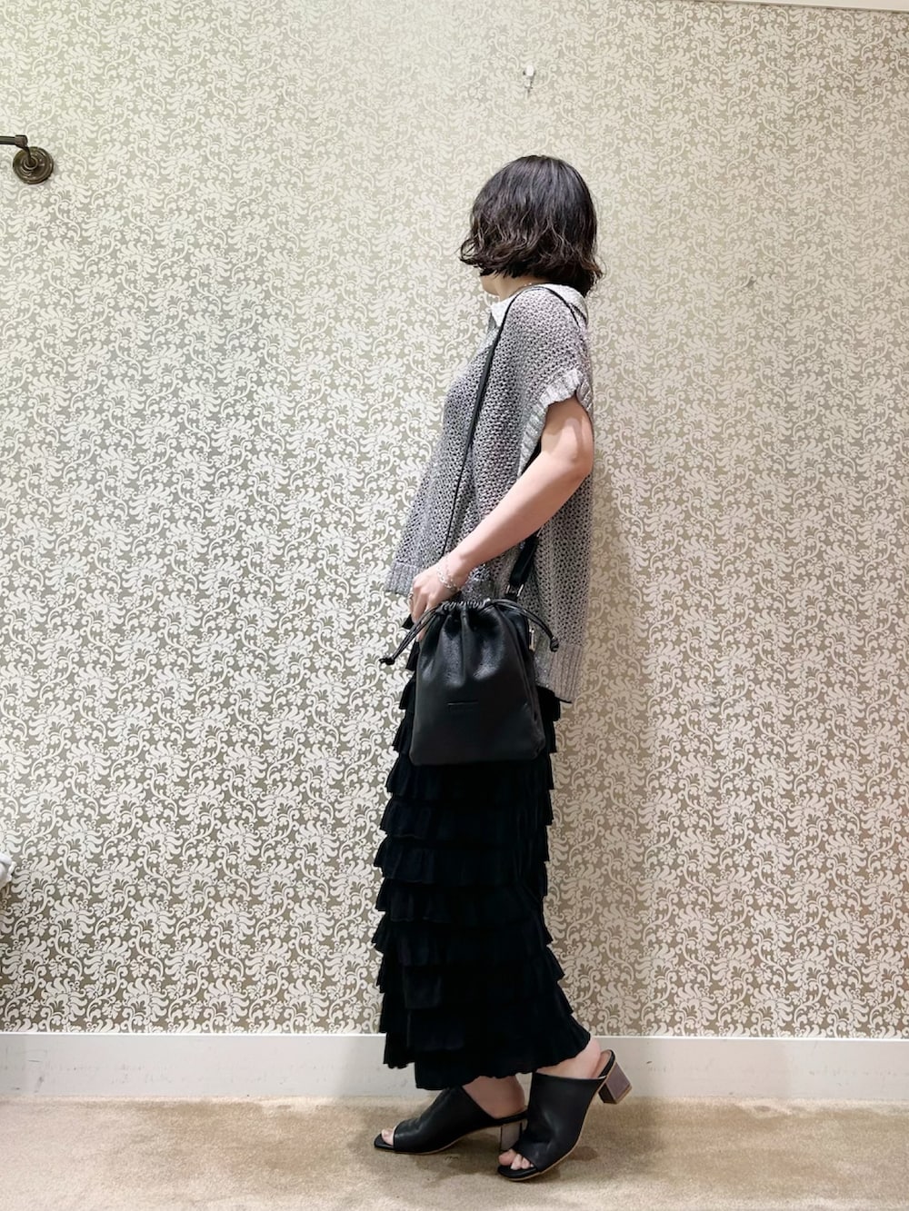 ブラック系のスカート、シルバー系のTシャツ/カットソー、ブラック系のトートバッグを着用したレディースの春コーディネートの2枚目の写真