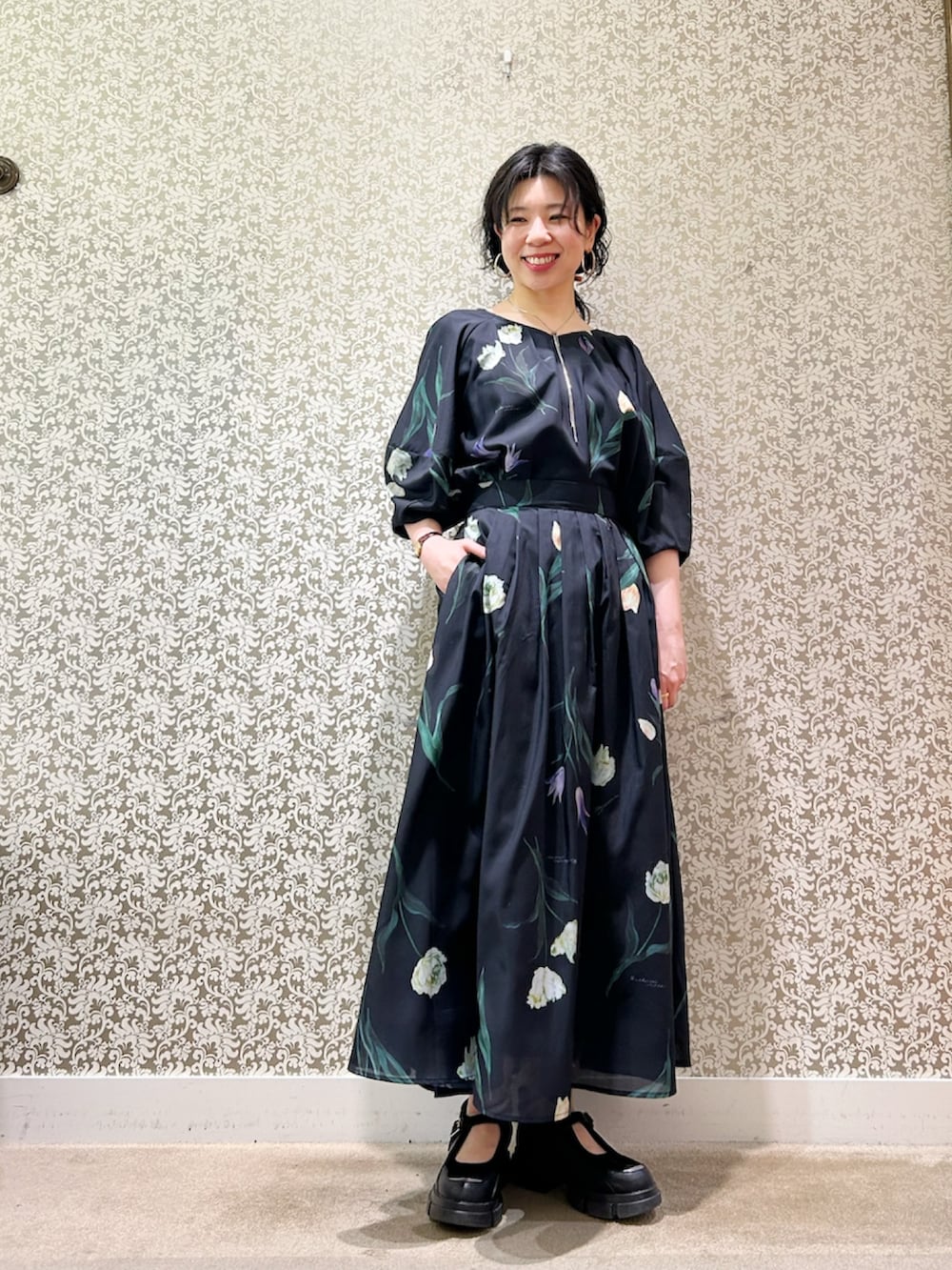 グリーン系のニット/セーター、ブルー系のシャツ/ブラウス、ブルー系のスカートを着用したレディースの春コーディネートの2枚目の写真