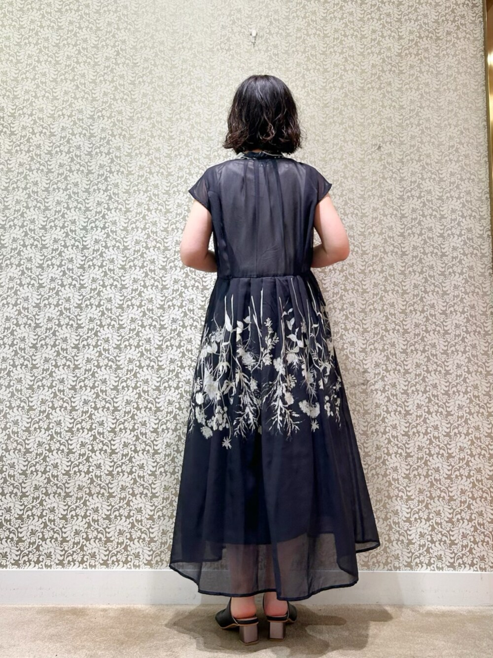 ブラック系のワンピースを着用したレディースの春コーディネートの3枚目の写真