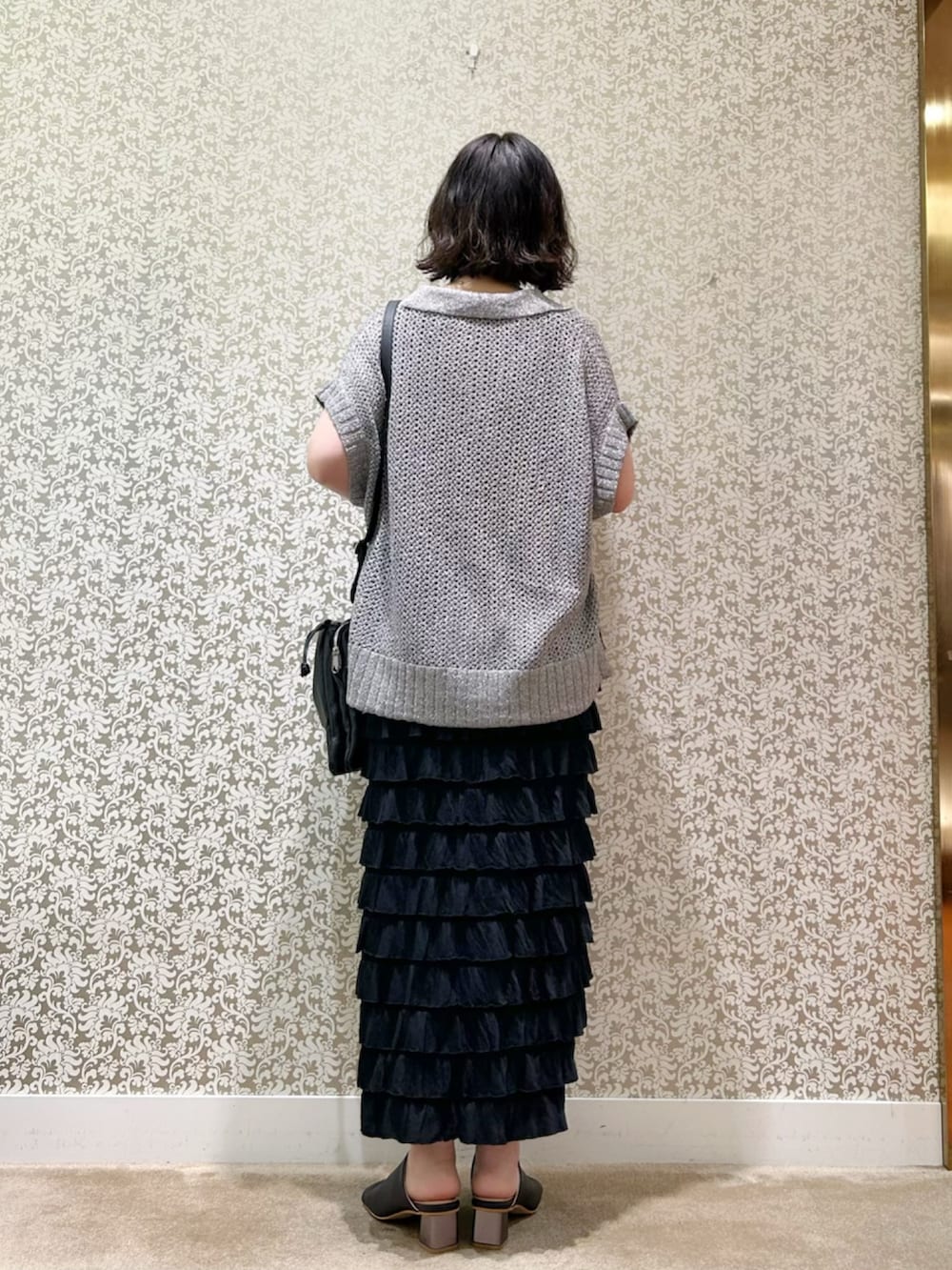 ブラック系のスカート、シルバー系のTシャツ/カットソー、ブラック系のトートバッグを着用したレディースの春コーディネートの3枚目の写真