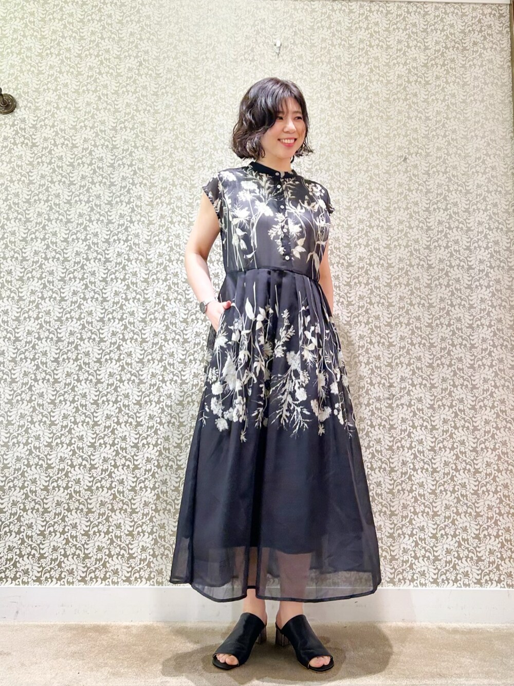 ブラック系のワンピースを着用したレディースの春コーディネートの2枚目の写真