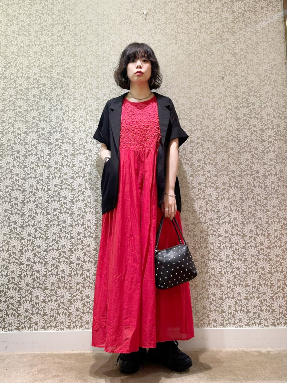 レッド系のワンピース、ブラック系のトートバッグを着用したレディースの春コーディネートの3枚目の写真
