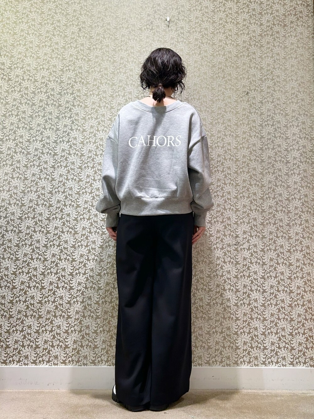 グレー系のスウェット、ブラック系のその他パンツ、ホワイト系のブーツを着用したレディースの冬コーディネートの2枚目の写真