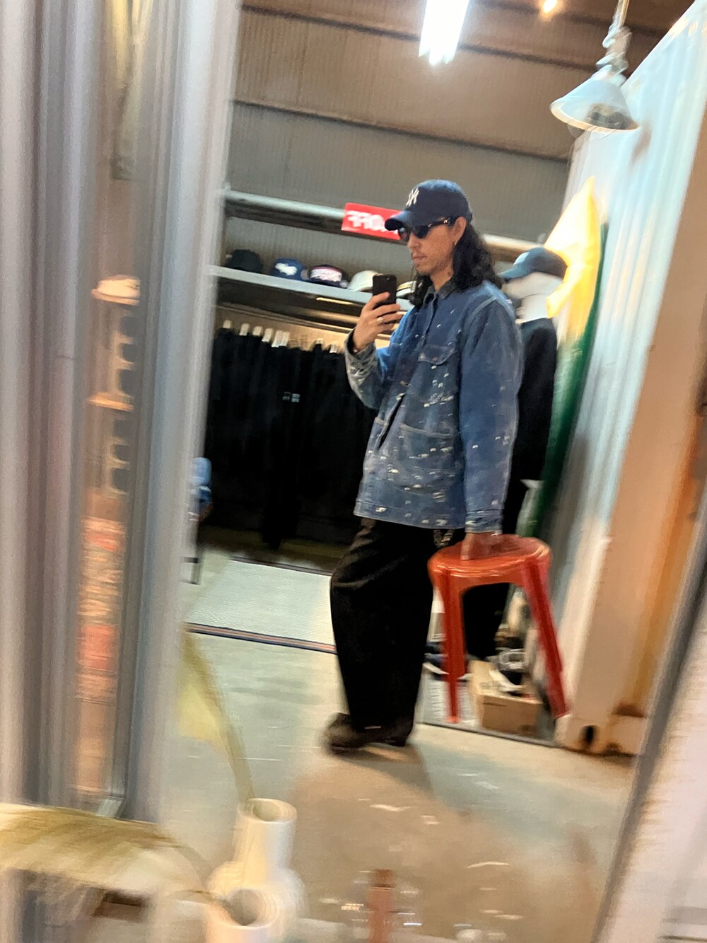 ブラック系のスラックス、ブラック系のブーツ、ブルー系のデニムジャケットを着用したメンズの冬コーディネートの4枚目の写真