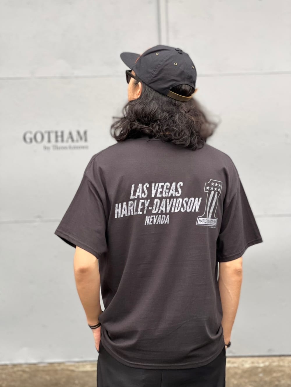 ブラック系のTシャツ/カットソー、ブラック系のスラックス、ブラック系のスニーカーを着用したメンズの春コーディネートの4枚目の写真