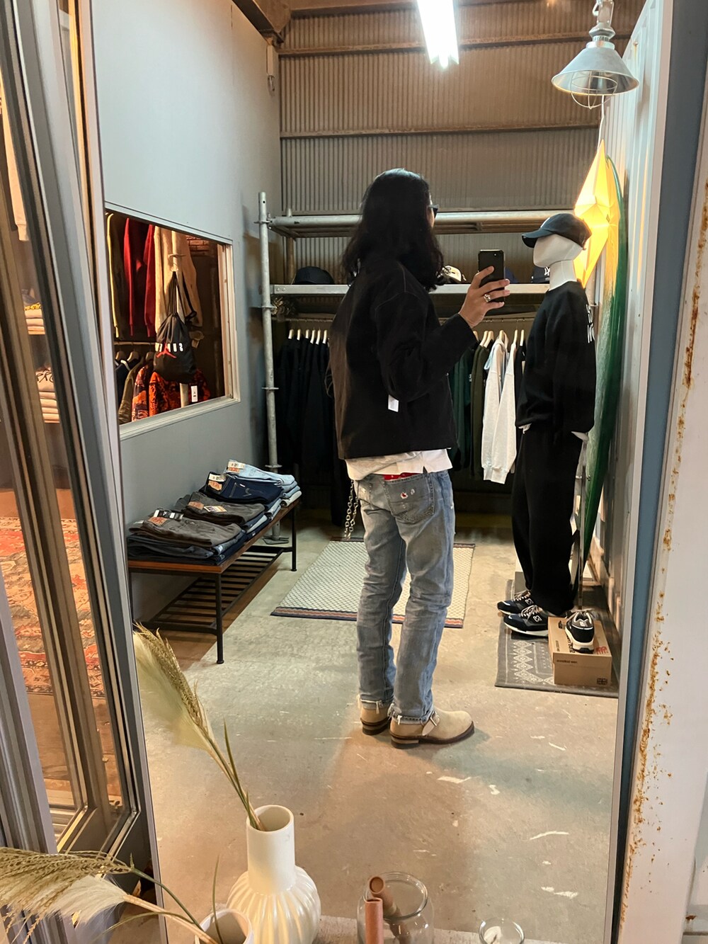 ベージュ系のブーツ、ブルー系のデニムパンツ、ブラック系のその他アウターを着用したメンズの冬コーディネートの3枚目の写真