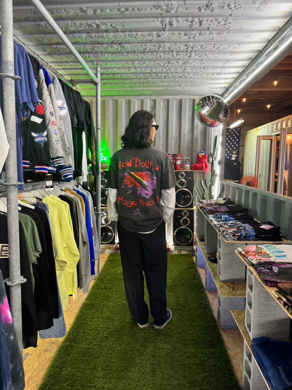 ブラック系のTシャツ/カットソー、ブラック系のスラックス、ブラック系のスニーカーを着用したメンズの秋コーディネートの2枚目の写真