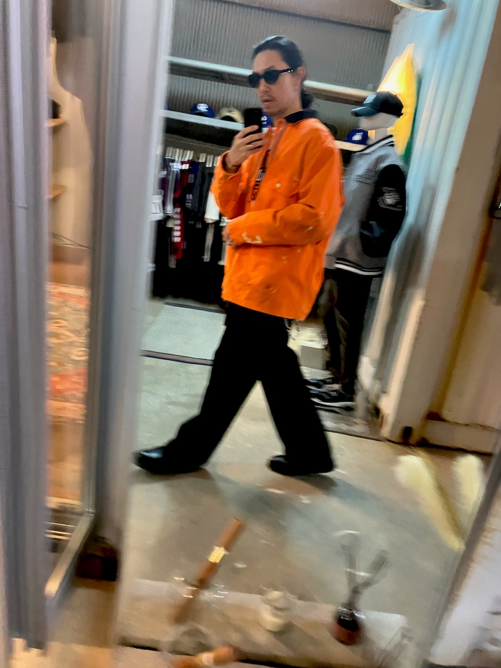 オレンジ系のカバーオール、ブラック系のスラックス、ブラック系のブーツを着用したメンズの冬コーディネートの5枚目の写真