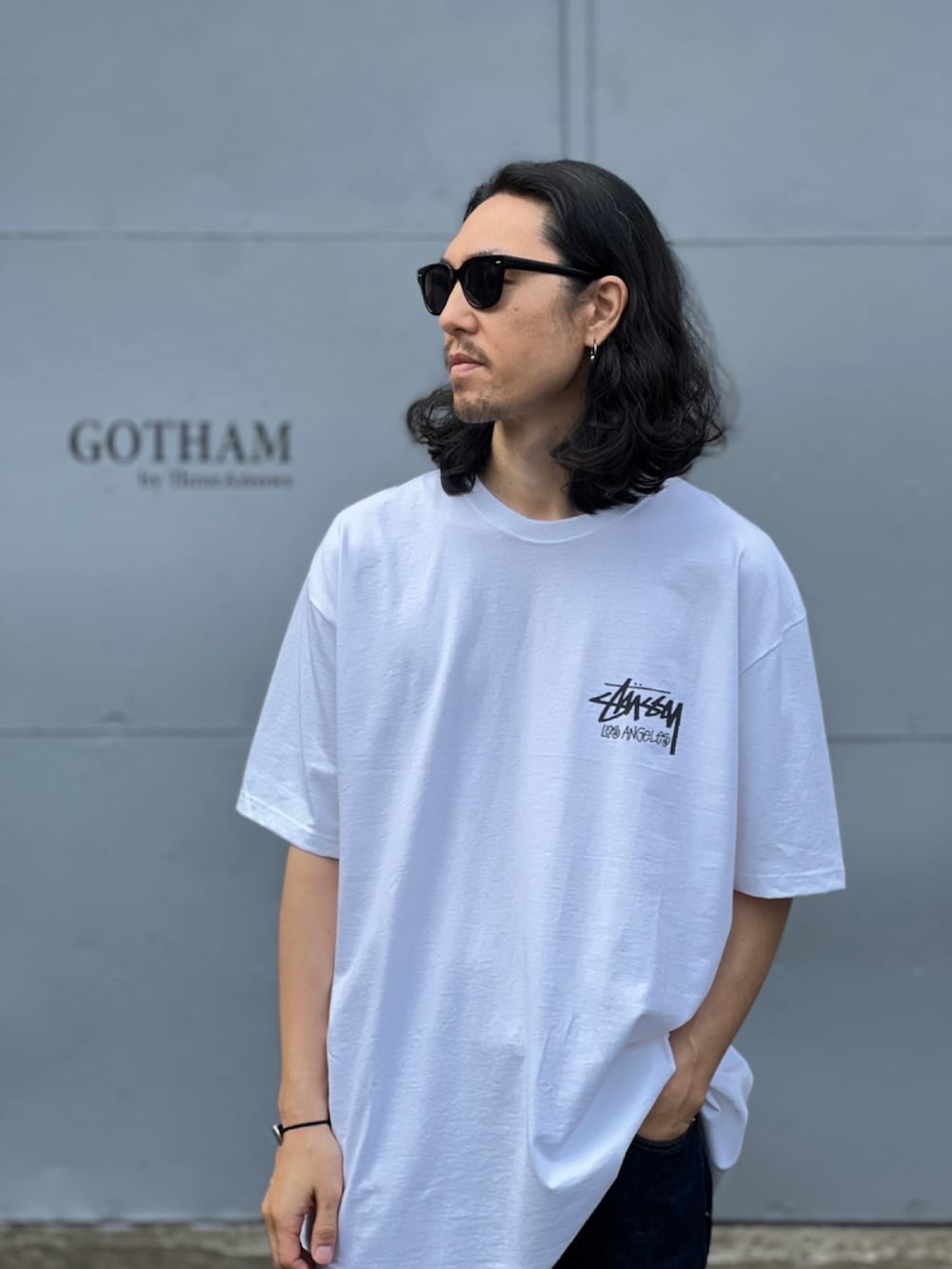 ホワイト系のTシャツ/カットソー、ブルー系のデニムパンツ、ブラック系のスニーカーを着用したメンズの春コーディネートの3枚目の写真