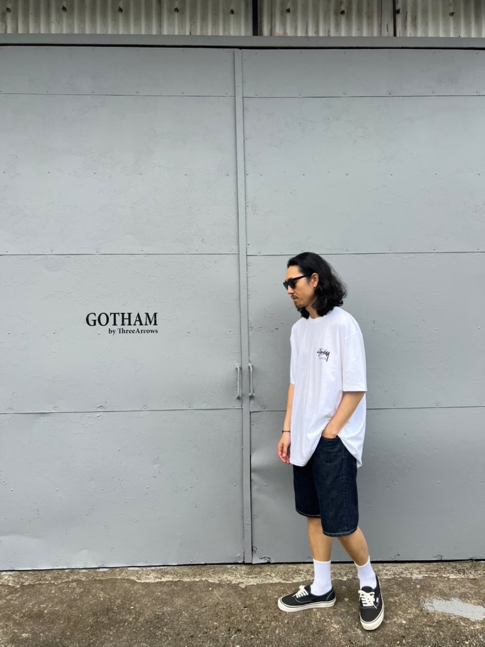 ホワイト系のTシャツ/カットソー、ブルー系のデニムパンツ、ブラック系のスニーカーを着用したメンズの春コーディネートの2枚目の写真