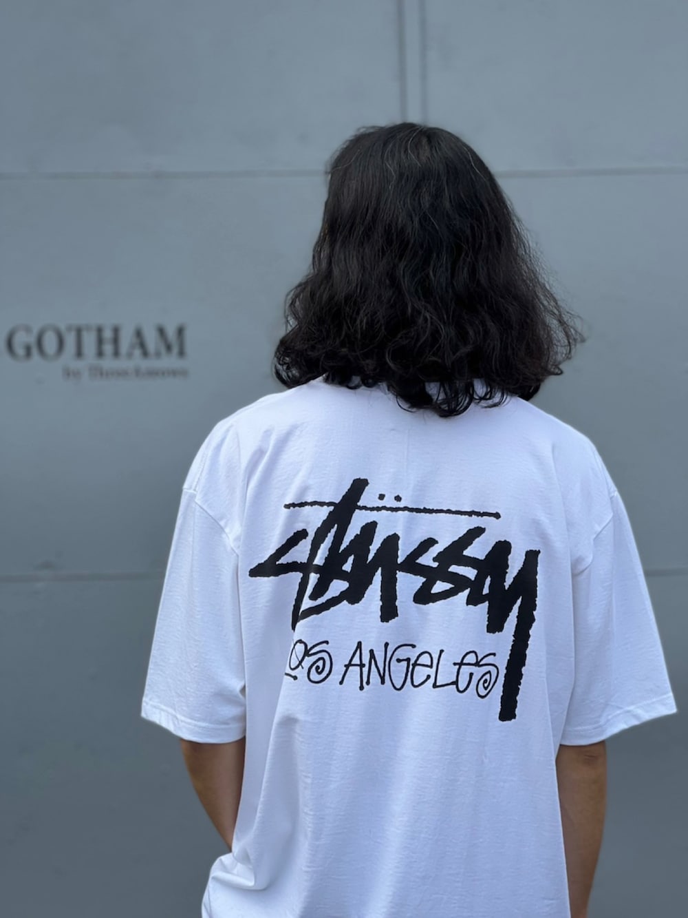 ホワイト系のTシャツ/カットソー、ブルー系のデニムパンツ、ブラック系のスニーカーを着用したメンズの春コーディネートの4枚目の写真