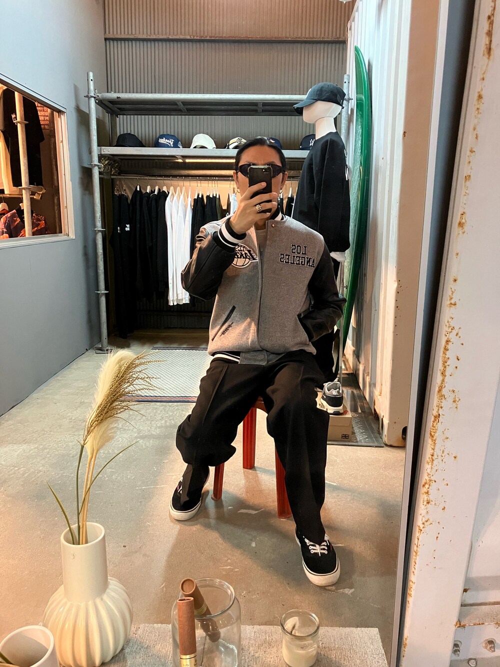 グレー系のスタジャン、ブラック系のスラックス、ブラック系のスニーカーを着用したメンズの秋コーディネートの2枚目の写真