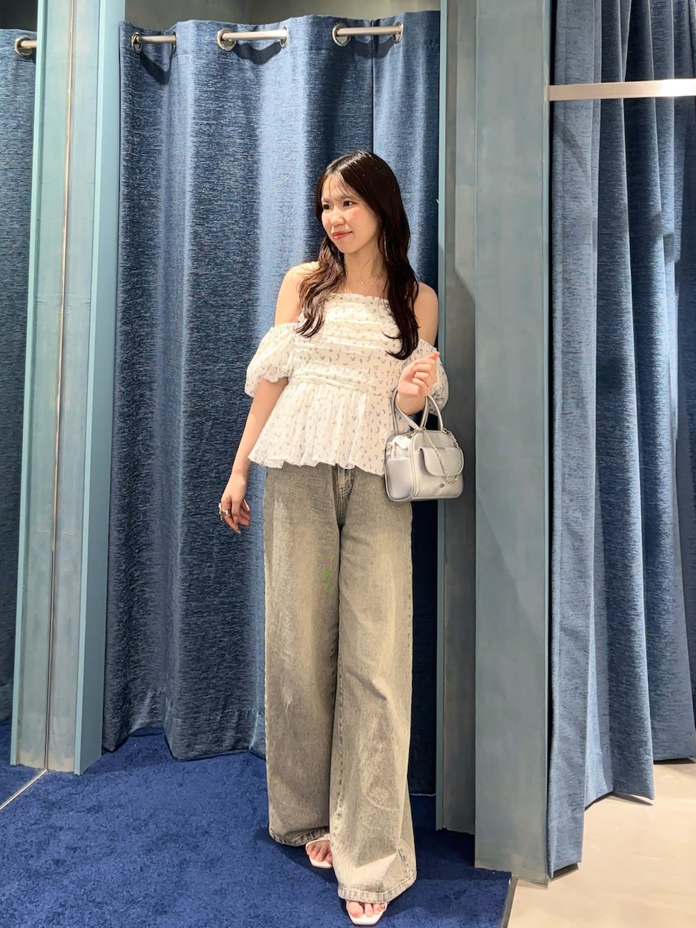 ホワイト系のシャツ/ブラウス、ブルー系のデニムパンツ、シルバー系のボストンバッグを着用したレディースの春コーディネートの3枚目の写真