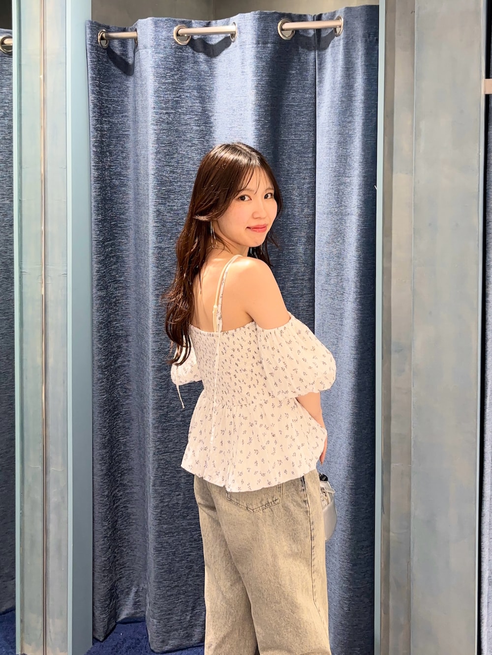 ホワイト系のシャツ/ブラウス、ブルー系のデニムパンツ、シルバー系のボストンバッグを着用したレディースの春コーディネートの5枚目の写真