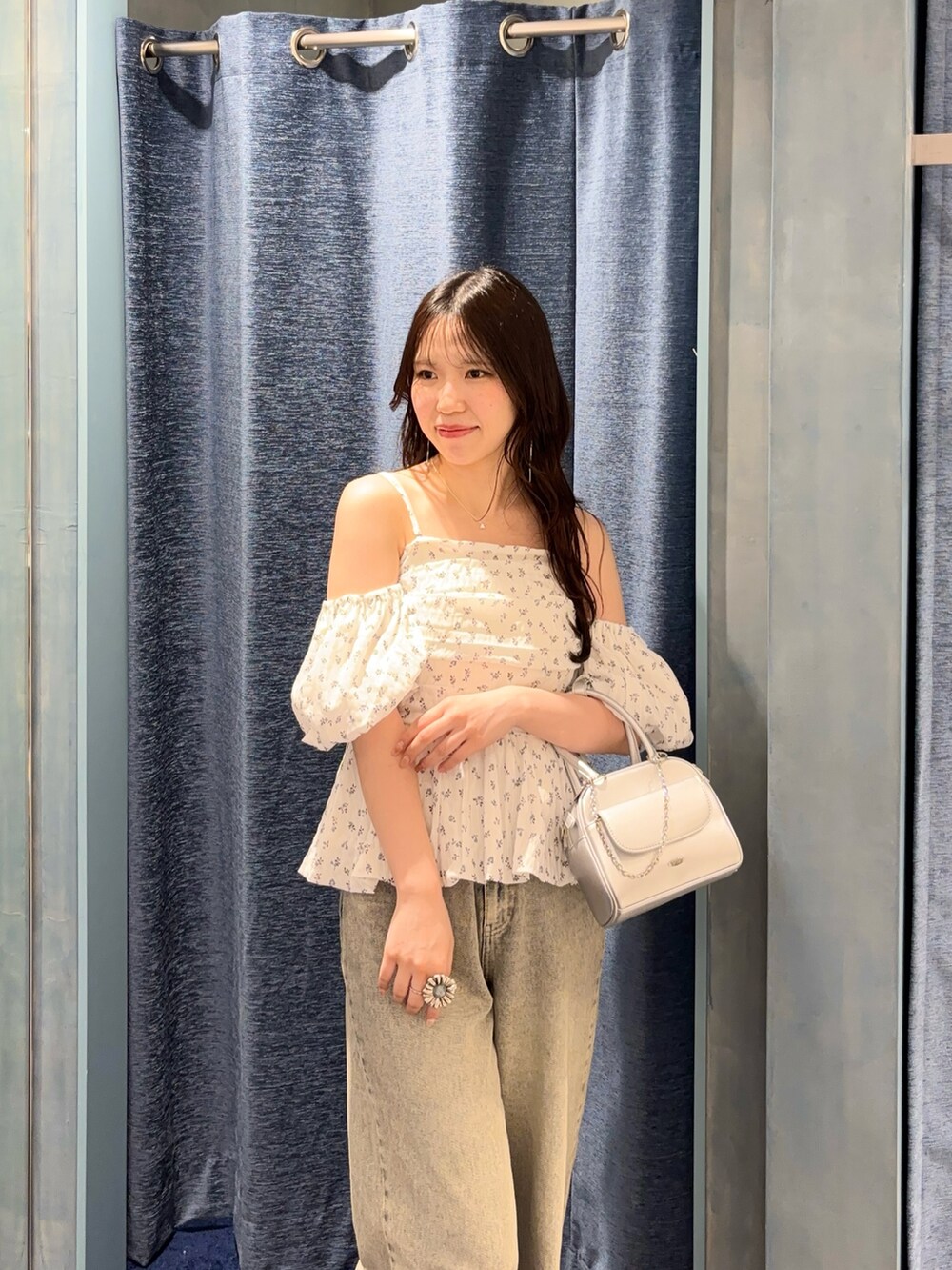 ホワイト系のシャツ/ブラウス、ブルー系のデニムパンツ、シルバー系のボストンバッグを着用したレディースの春コーディネートの4枚目の写真