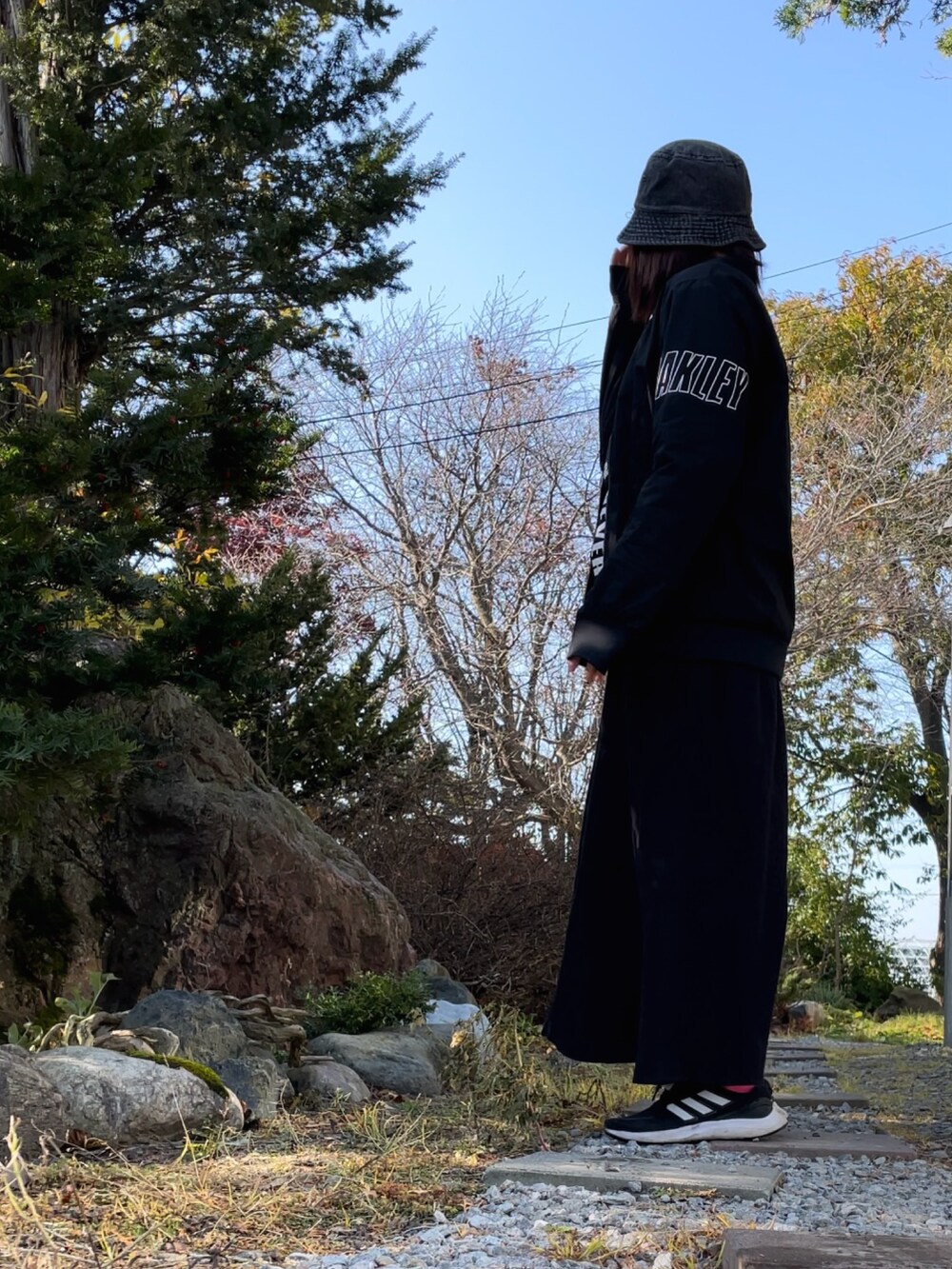 ブラック系のブルゾン、ブラック系のワンピース、ブラック系のスニーカーを着用したレディースの秋コーディネートの3枚目の写真