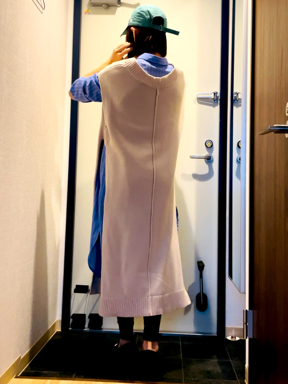 ブルー系のシャツワンピース、ホワイト系のワンピース、ブラック系のパンプスを着用したレディースの秋コーディネートの3枚目の写真