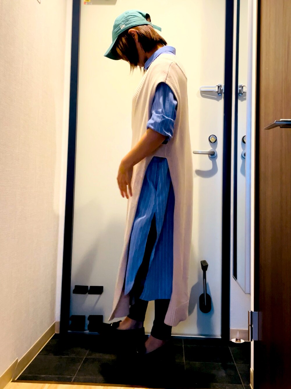 ブルー系のシャツワンピース、ホワイト系のワンピース、ブラック系のパンプスを着用したレディースの秋コーディネートの2枚目の写真