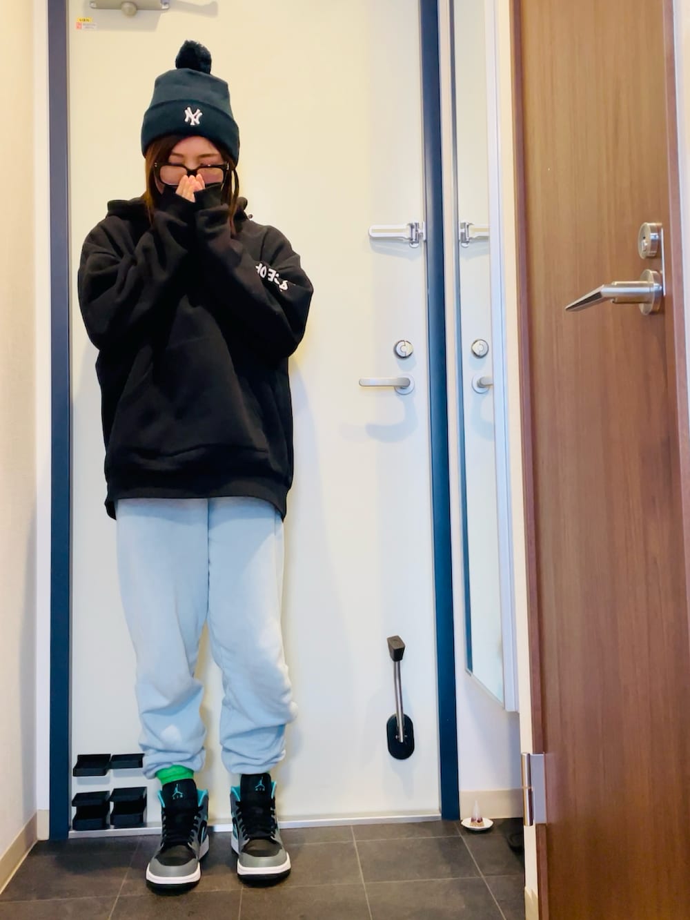 ブラック系のパーカー、ブルー系のスウェット、グレー系のスニーカーを着用したレディースの冬コーディネートの2枚目の写真