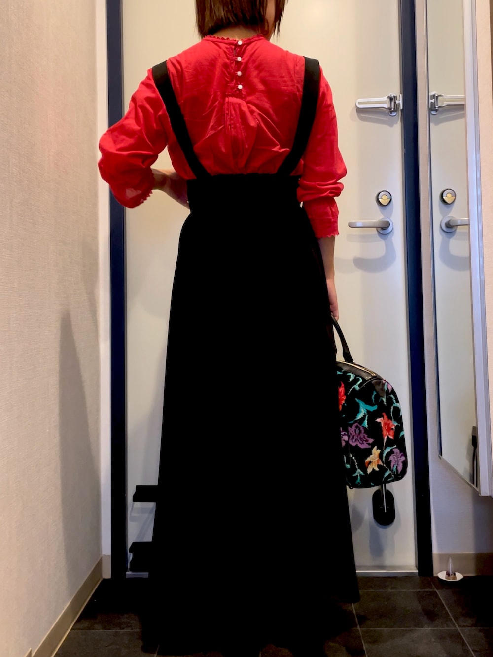 レッド系のシャツ/ブラウス、ブラック系のサロペット/オーバーオールを着用したレディースの秋コーディネートの3枚目の写真