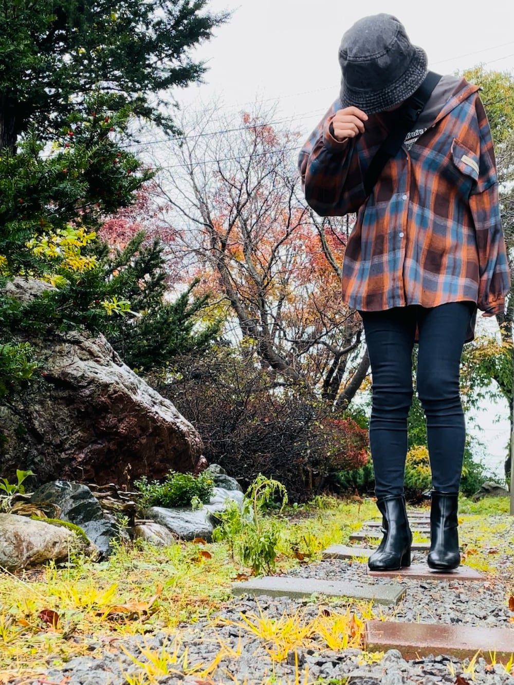 ブラック系のショルダーバッグ、ブラウン系のシャツ/ブラウス、ブラック系のデニムパンツを着用したレディースの秋コーディネートの2枚目の写真