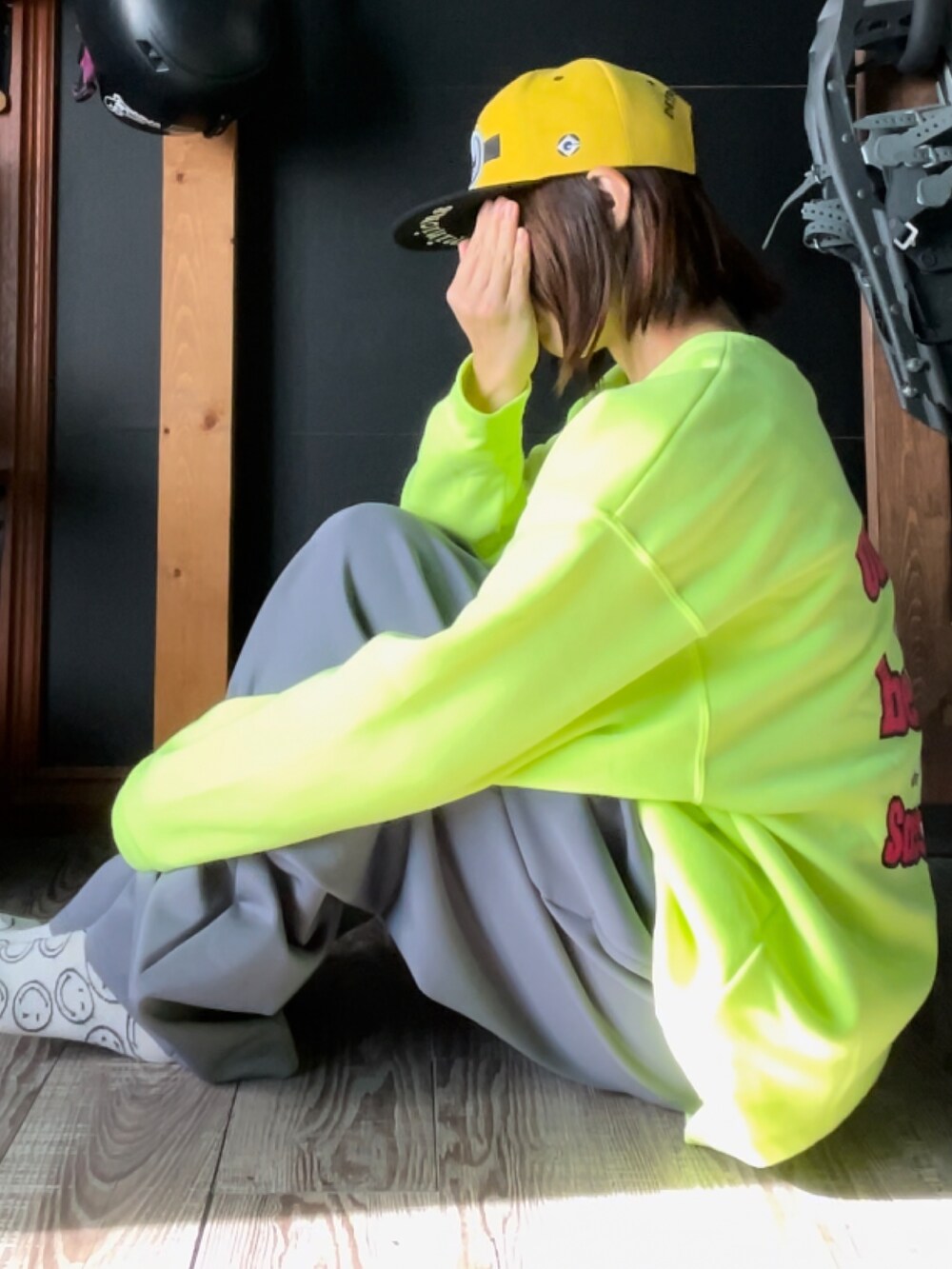 イエロー系のスウェット、グレー系のその他パンツ、イエロー系のキャップを着用したレディースの秋コーディネートの2枚目の写真