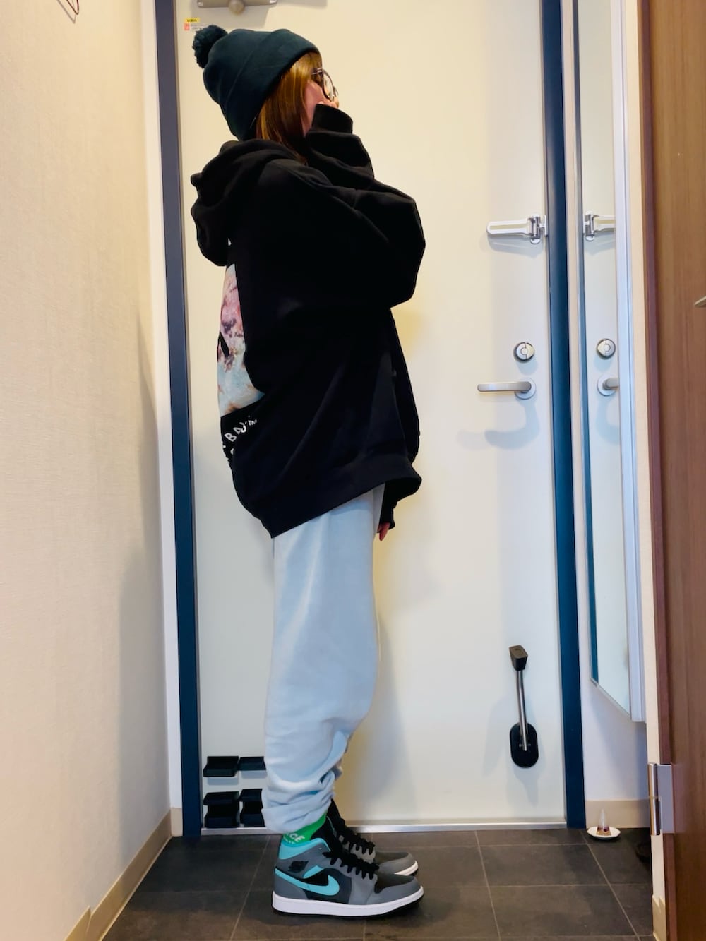 ブラック系のパーカー、ブルー系のスウェット、グレー系のスニーカーを着用したレディースの冬コーディネートの3枚目の写真