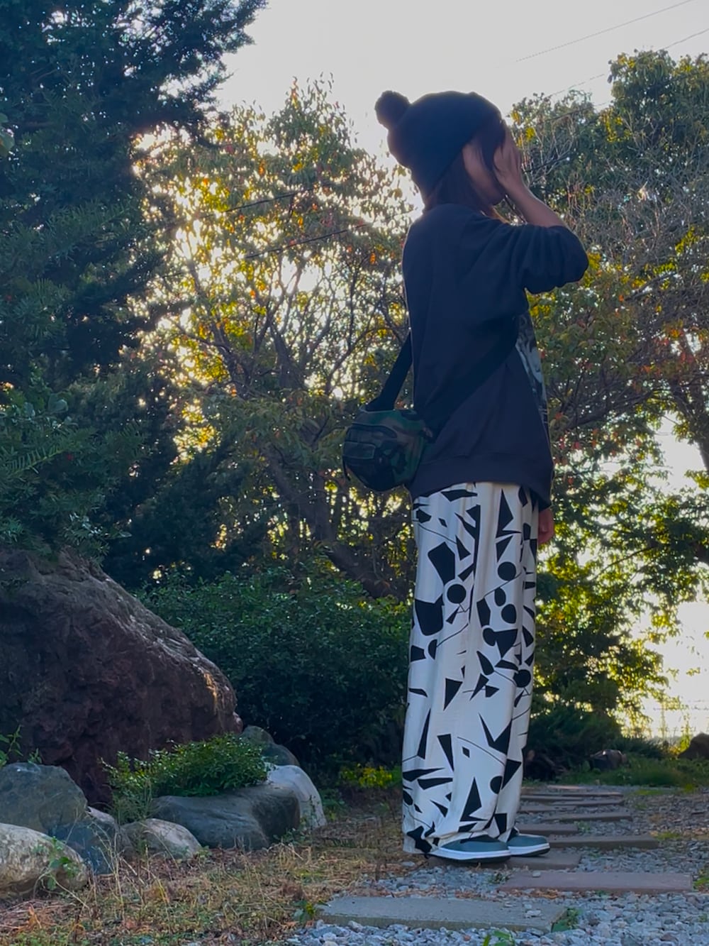 ホワイト系のパンツ、グレー系のスニーカー、グレー系のスウェットを着用したレディースの秋コーディネートの2枚目の写真