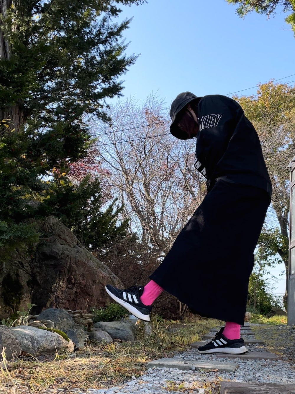 ブラック系のブルゾン、ブラック系のワンピース、ブラック系のスニーカーを着用したレディースの秋コーディネートの2枚目の写真