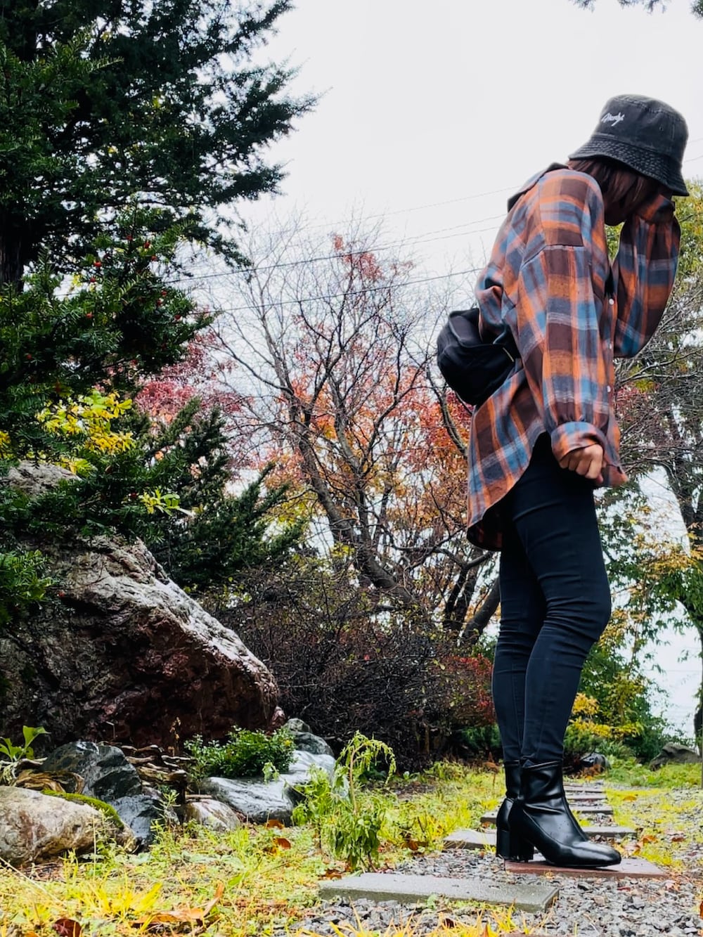 ブラック系のショルダーバッグ、ブラウン系のシャツ/ブラウス、ブラック系のデニムパンツを着用したレディースの秋コーディネートの3枚目の写真