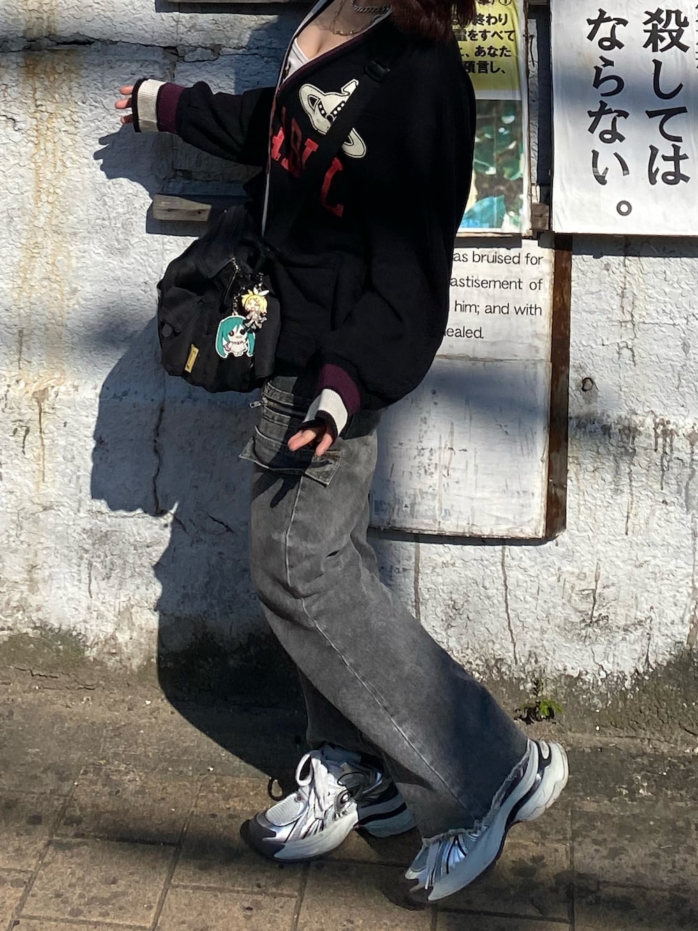 ブラック系のカーディガン/ボレロ、ホワイト系のタンクトップ、グレー系のデニムパンツを着用したレディースの秋コーディネートの2枚目の写真