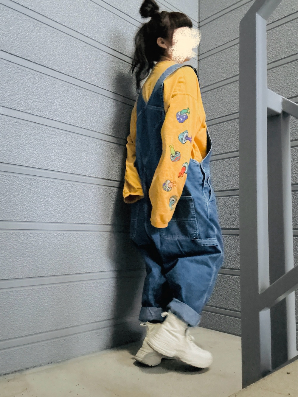 ベージュ系のスニーカー、ブルー系のつなぎ/オールインワン、イエロー系のTシャツ/カットソーを着用したレディースの春コーディネートの3枚目の写真