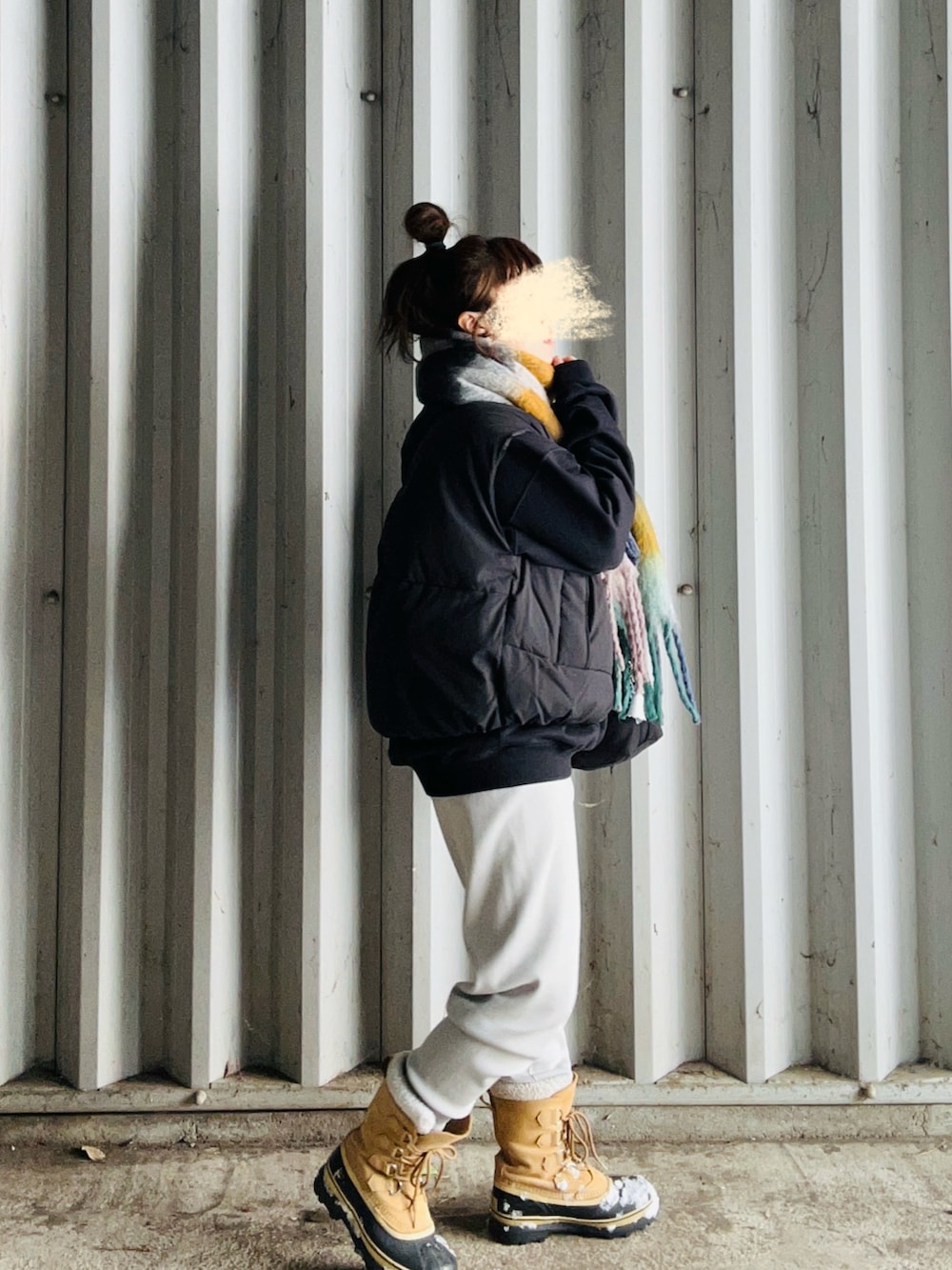 ブラック系のダウンベスト、ブラック系のスウェット、グレー系のその他パンツを着用したレディースの冬コーディネートの3枚目の写真