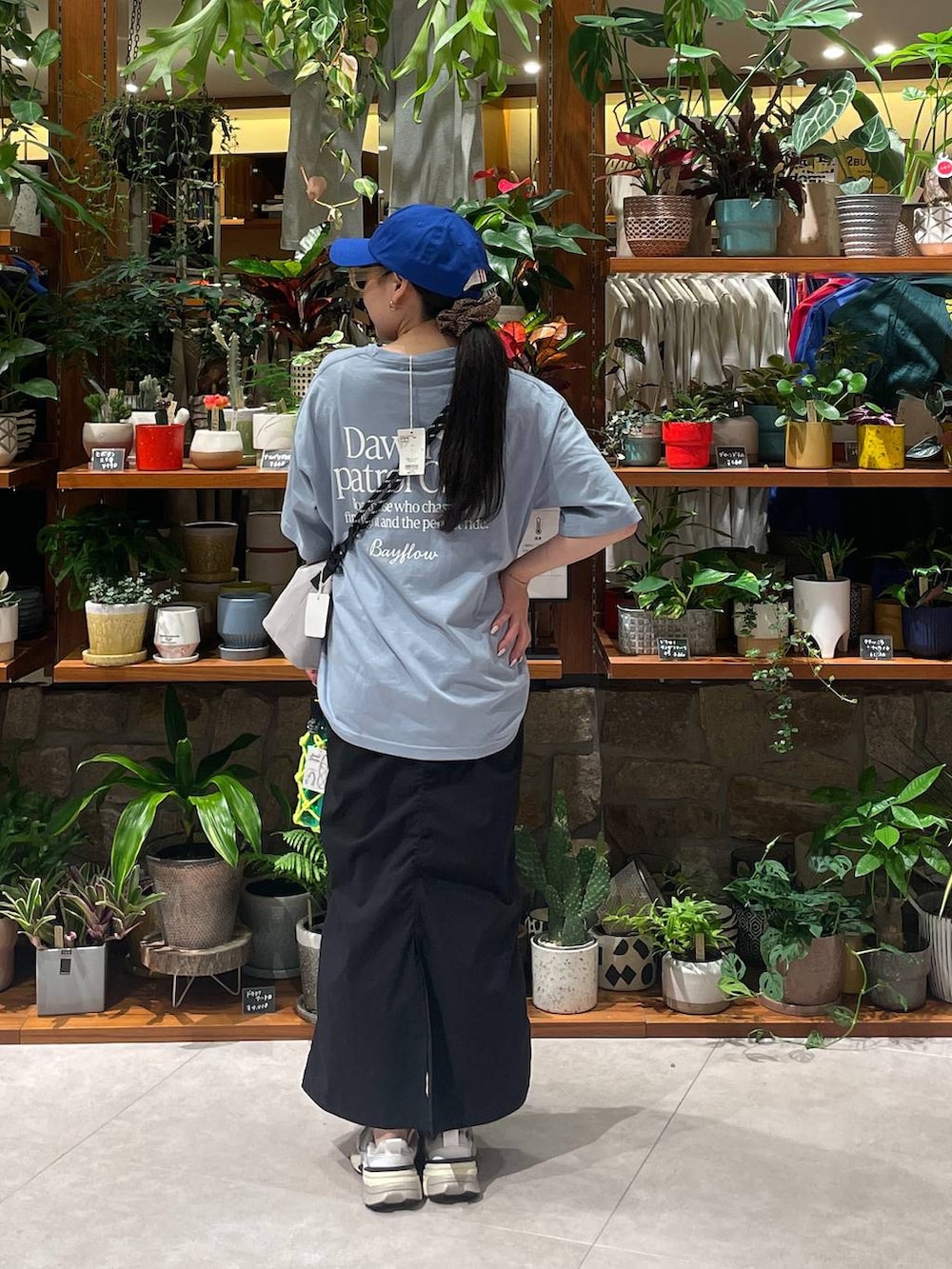 ブラック系のスカート、グレー系のショルダーバッグ、グリーン系の水筒を着用したレディースの春コーディネートの3枚目の写真