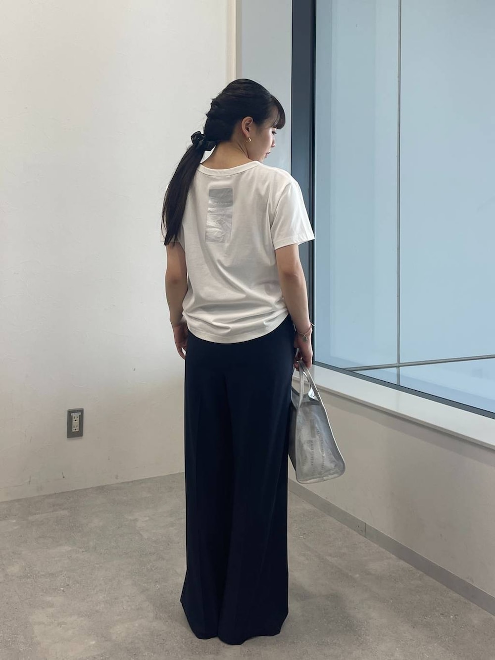 ホワイト系のTシャツ/カットソー、シルバー系のハンドバッグ、ブラック系のサンダルを着用したレディースの夏コーディネートの3枚目の写真