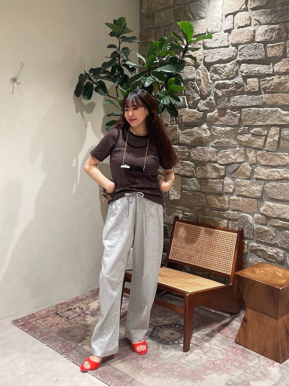 ブラウン系のTシャツ/カットソー、レッド系のサンダル、グレー系のその他パンツを着用したレディースの春コーディネートの2枚目の写真