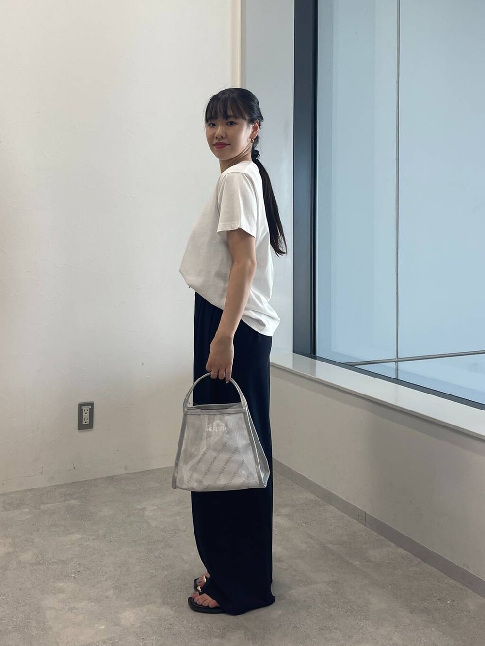 ホワイト系のTシャツ/カットソー、シルバー系のハンドバッグ、ブラック系のサンダルを着用したレディースの夏コーディネートの2枚目の写真