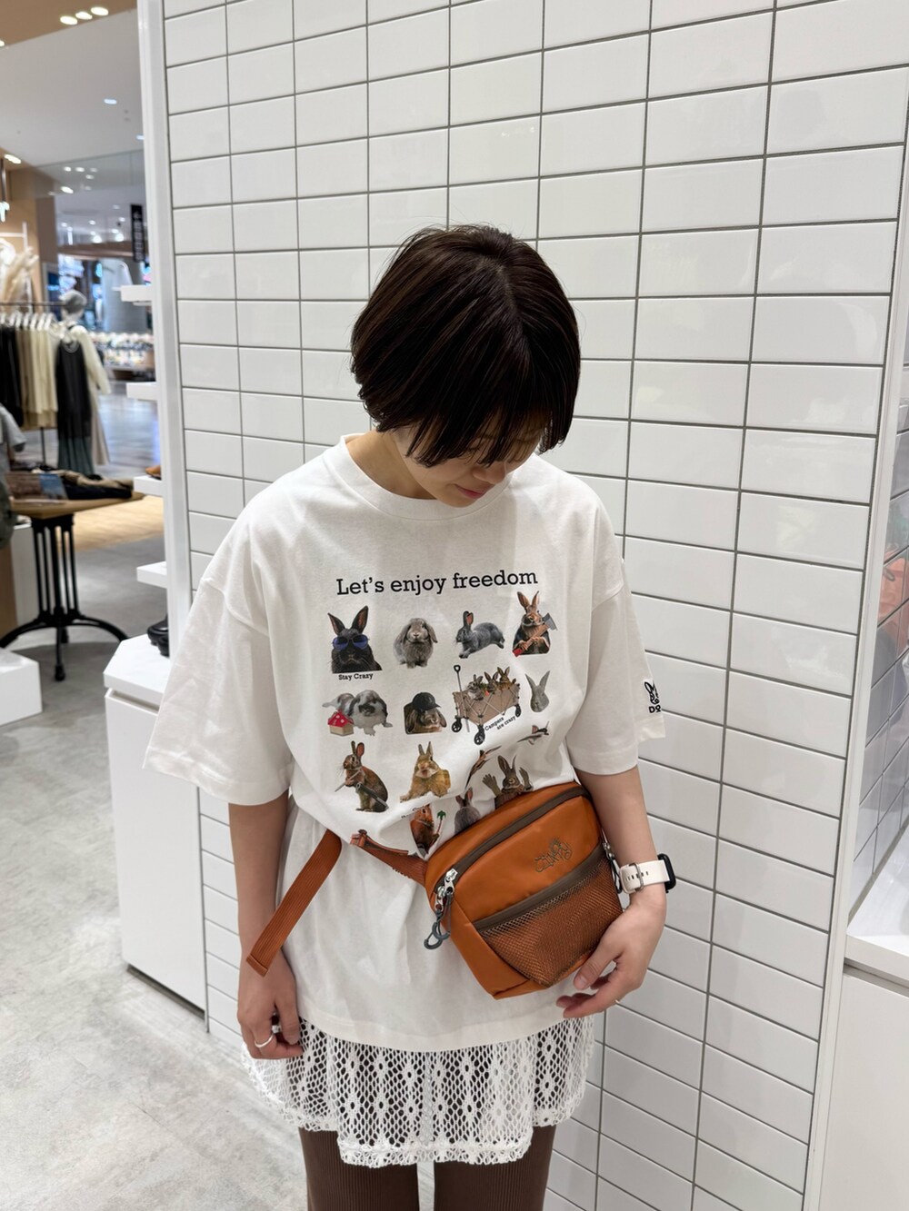 ホワイト系のTシャツ/カットソー、オレンジ系のボディバッグ/ウエストポーチ、ホワイト系のキャミソールを着用したレディースの春コーディネートの5枚目の写真