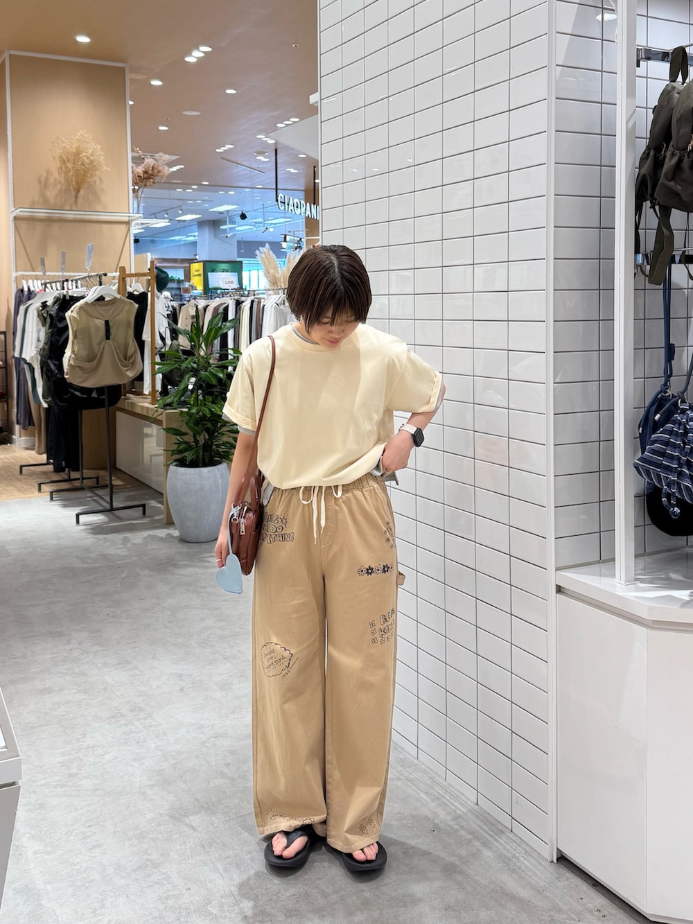 ホワイト系のTシャツ/カットソー、ベージュ系のサロペット/オーバーオール、ブラウン系のトートバッグを着用したレディースの夏コーディネートの2枚目の写真