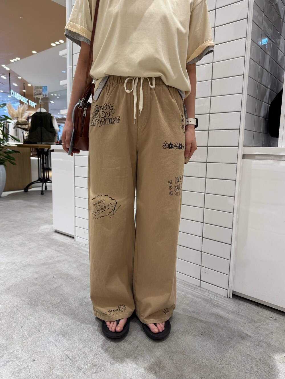 ホワイト系のTシャツ/カットソー、ベージュ系のサロペット/オーバーオール、ブラウン系のトートバッグを着用したレディースの夏コーディネートの5枚目の写真