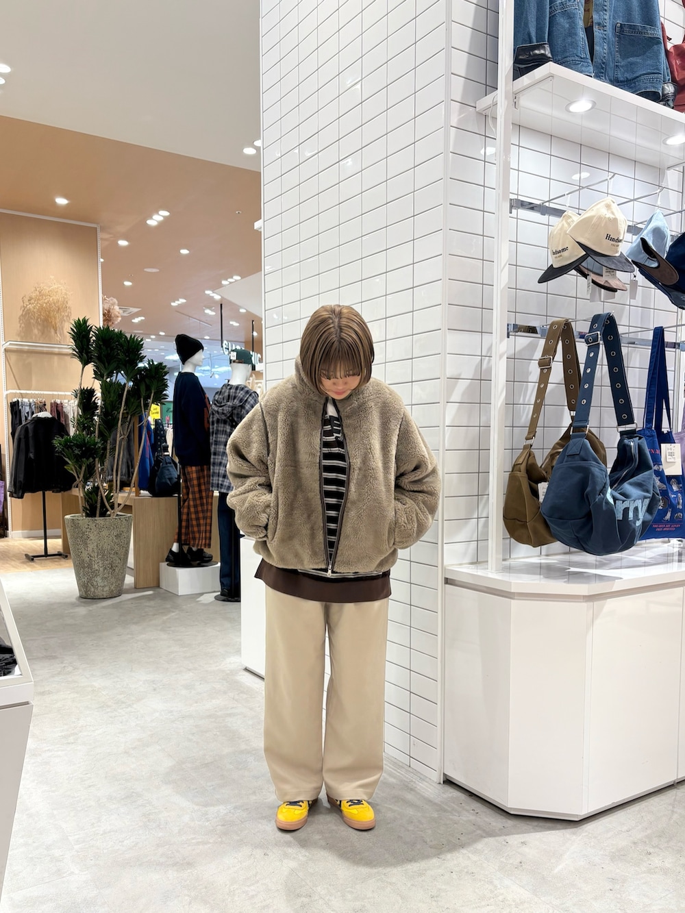 ベージュ系のスラックス、ブラウン系のTシャツ/カットソー、ベージュ系のブルゾンを着用したレディースの秋コーディネートの2枚目の写真