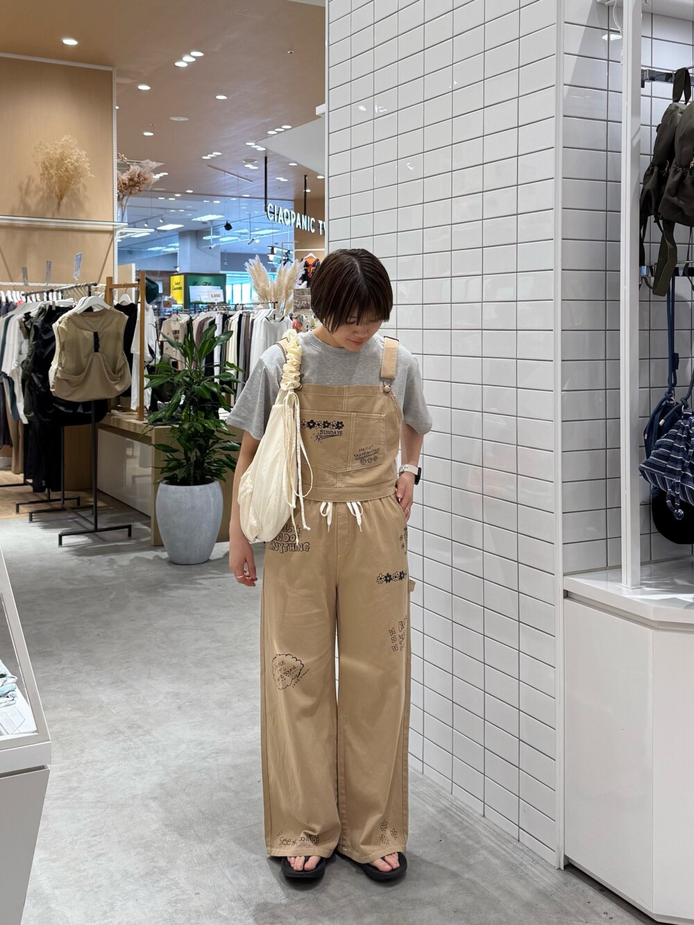 ベージュ系のサロペット/オーバーオール、ホワイト系のTシャツ/カットソー、ホワイト系のトートバッグを着用したレディースの夏コーディネートの2枚目の写真