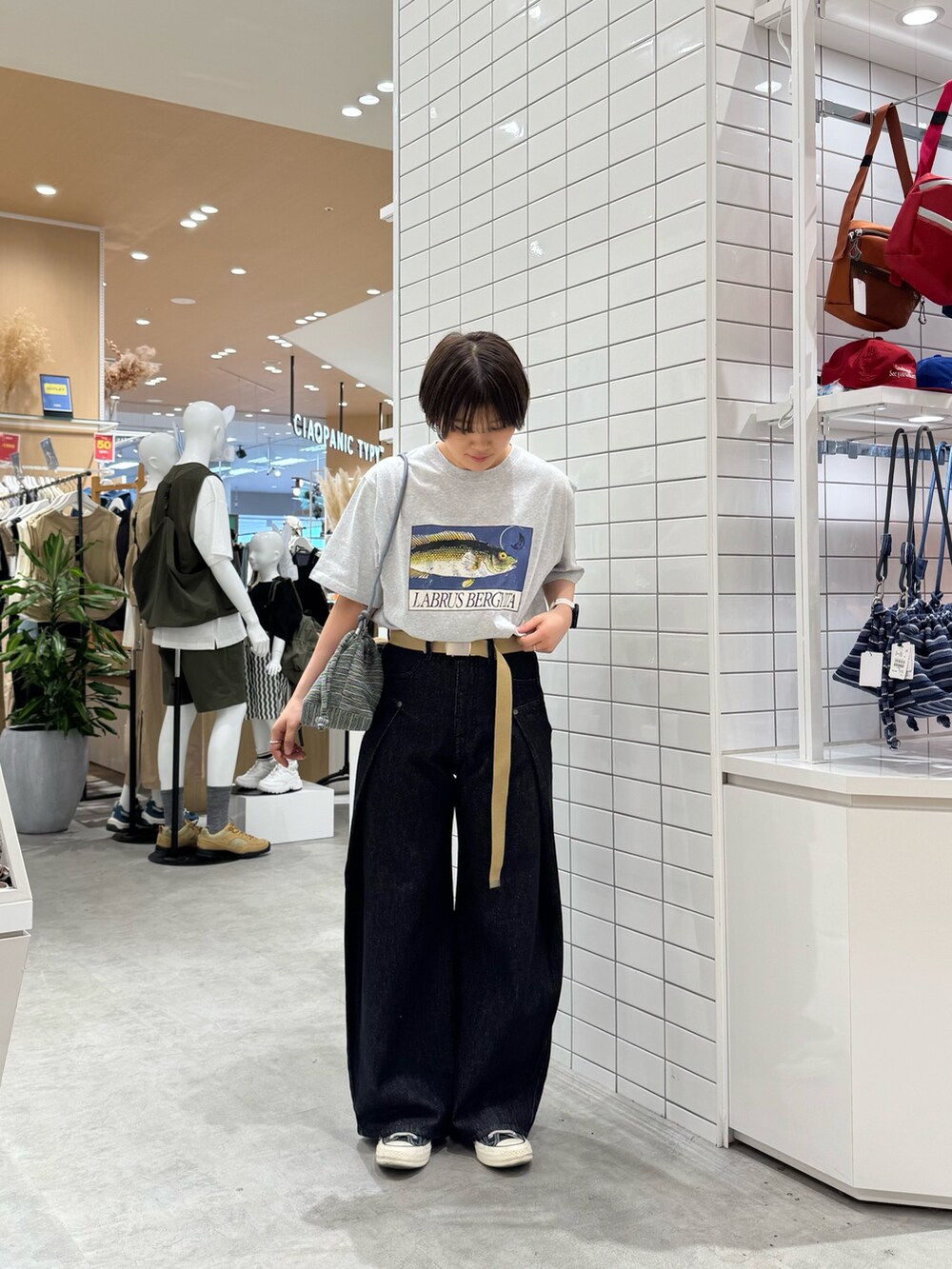 グレー系のTシャツ/カットソー、ブラック系のデニムパンツ、グリーン系のショルダーバッグを着用したレディースの夏コーディネートの3枚目の写真