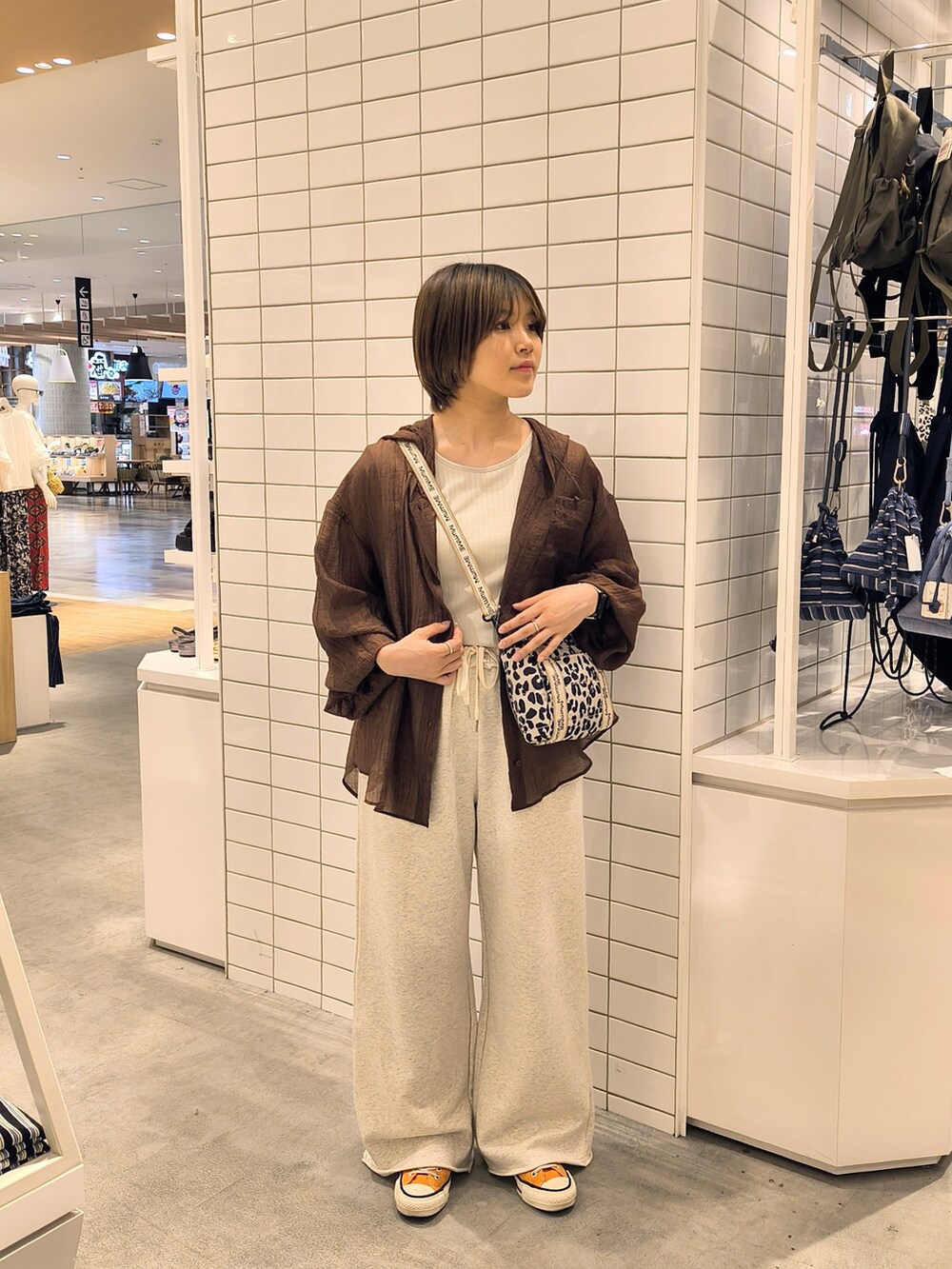 ホワイト系のスウェットパンツ、ホワイト系のショルダーバッグ、グレー系のタンクトップを着用したレディースの夏コーディネートの2枚目の写真