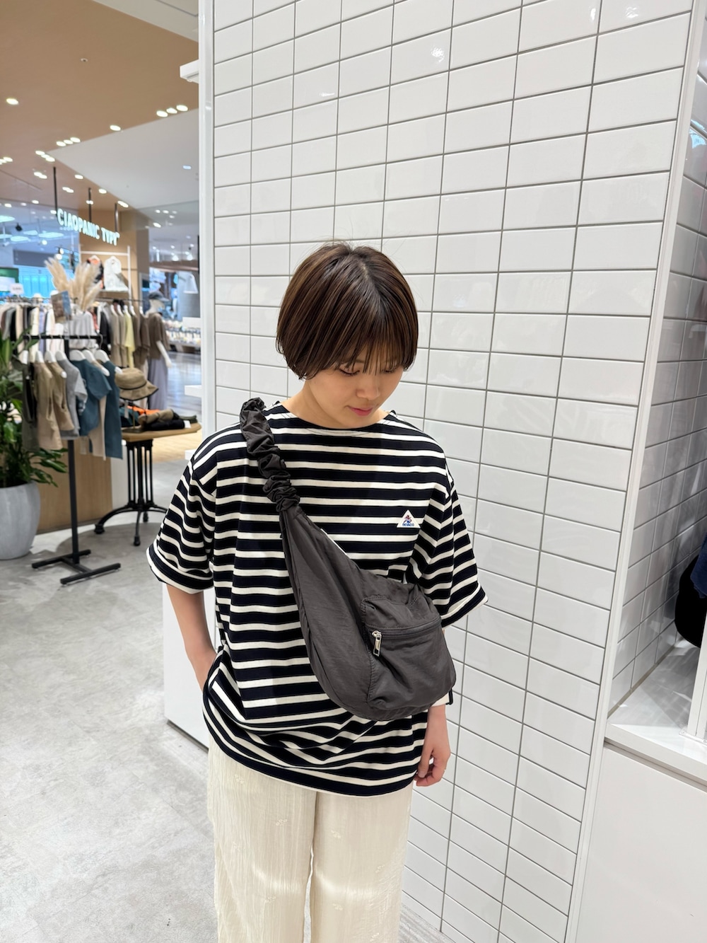 グレー系のトートバッグ、ブラック系のTシャツ/カットソー、ホワイト系のその他パンツを着用したレディースの夏コーディネートの4枚目の写真